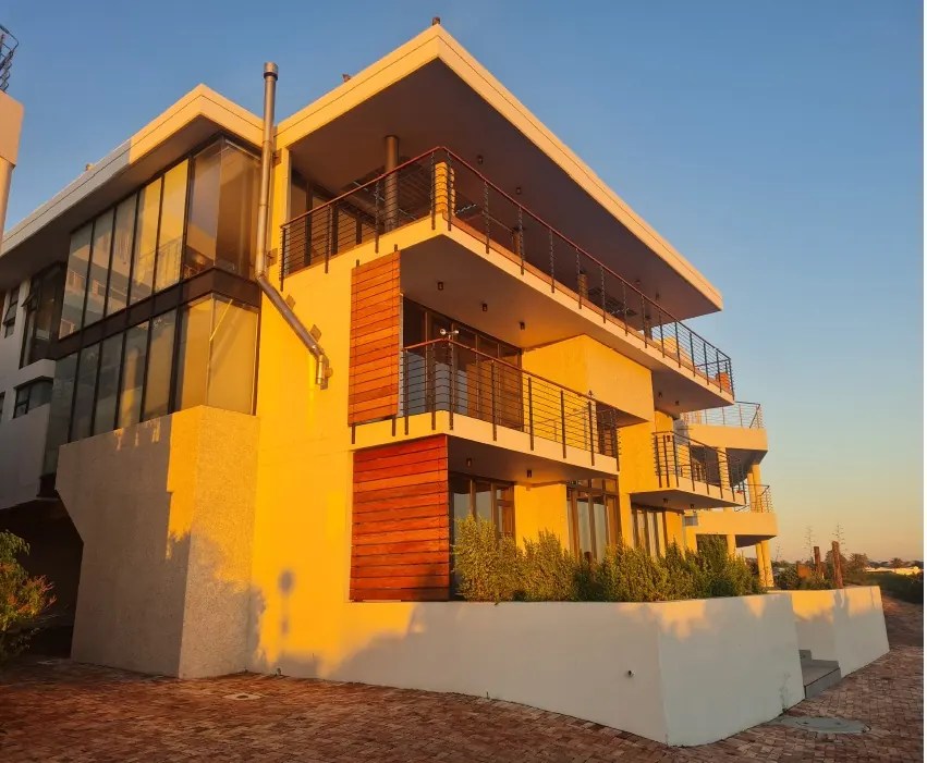 Apartment block at Summerbrooke at sunset, with cantilevered balconies, timber screens and cable balustrades
